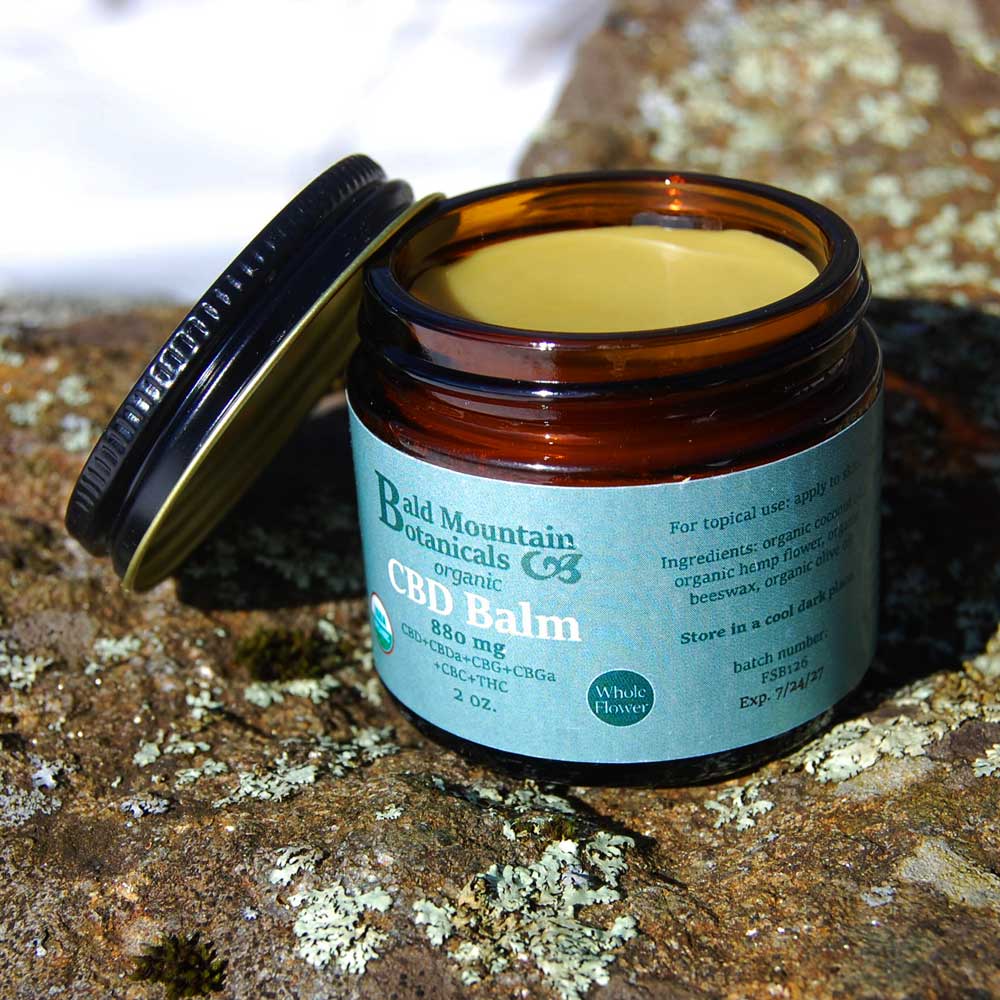 brown glass jar of organic whole flower CBD oil with lid off